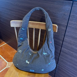 Détail du sac hobo en velours côtelé gris avec broderie chiot et étiquette Hope