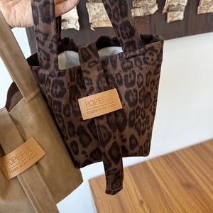 Detail of canvas tote bags with leopard print and khaki colors with leather patch labels