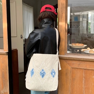 Off-white oversized tote bag with embroidery and blue denim patch on shoulder
