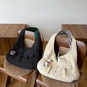 Macro detail of pleated tote bags with checkered lining and cute charms for commute