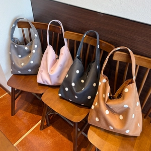 Nahaufnahme von vier großen gepunkteten Hobo-Taschen in Grau, Rosa, Schwarz und Braun