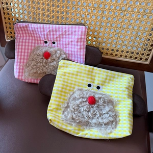 Close-up of cute plaid cosmetic bags with fuzzy cartoon embroidery and 3D details