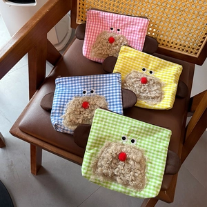 Detail of four colorful plaid cosmetic bags with cute 3D cartoon animal face on wooden chair