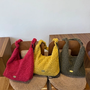 Detailed texture of plush drawstring hobo bags in wine red, yellow, and dark green