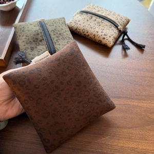 Detail van suède opbergzakjes met luipaardprint in drie kleuren en een metalen rits