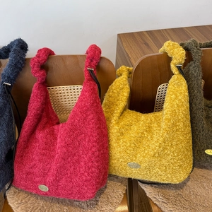 Detail of plush drawstring handbags showing handmade metal label and soft knit texture