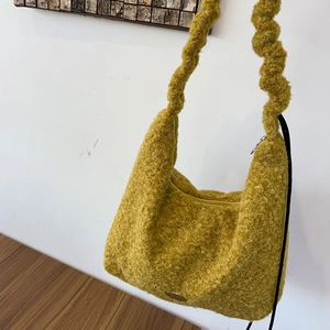 Detail of ginger yellow plush tote bag showing fuzzy lamb wool texture and knotted handle