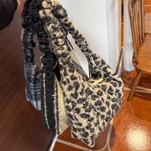 Detail of plush faux fur tote bags with scrunched handles in various leopard and plaid patterns