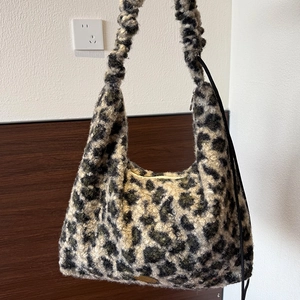 Detailed close-up of leopard print plush tote bag featuring a stylish ruched shoulder strap