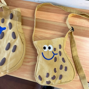 Simpatica borsa a tracolla in tela gialla a forma di arachide con viso a cartone