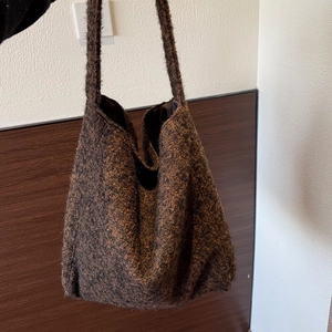 Dettaglio della borsa tote in peluche marrone con trama spessa e ampia tracolla imbottita