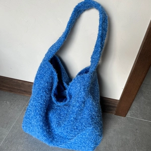 Dettaglio della borsa tote in peluche blu con morbida texture e ampio interno foderato