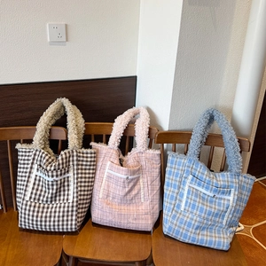 Close-up of plaid tote bags with plush teddy fleece handles and outer zipper pockets