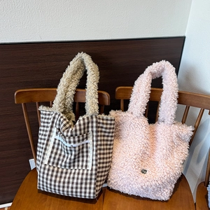 Detail of plush lamb wool tote bags in brown plaid and soft pink for winter fashion