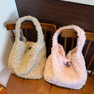 Detail of plush tote bags in beige and pink with decorative toggle button closure