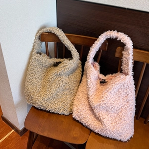 Detail of fleece tote bag with toggle button closure on a rustic wooden chair