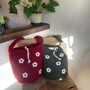 Detalle del bordado floral en el bolso tipo cubo de felpa con cordón ajustable