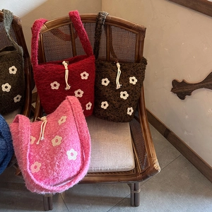 Detalle de los bolsos bombonera de punto con bordado floral y cordón con cuentas
