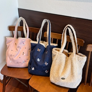 Détails de sacs cabas en laine d'agneau avec broderie cheval sur une chaise vintage