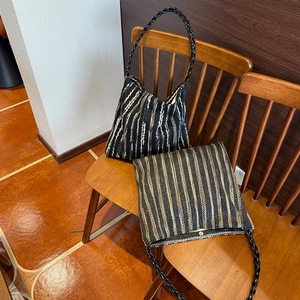 Detail of colorful woven stripe tote bags with leather handles on a wooden chair