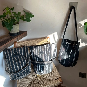 Detail shot of multi-color striped knit bucket bags with thick woven shoulder straps