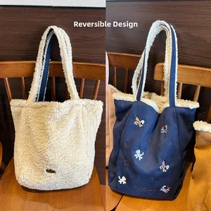 Détail du cabas réversible avec polaire douce et broderie animale sur daim bleu marine