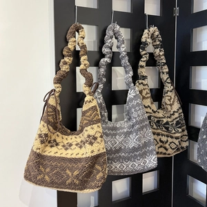 Detail of plush tote bags with geometric jacquard patterns and scrunchie shoulder straps