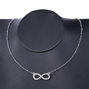 Close-up of infinity symbol pendant with rhinestones on a delicate silver bead chain