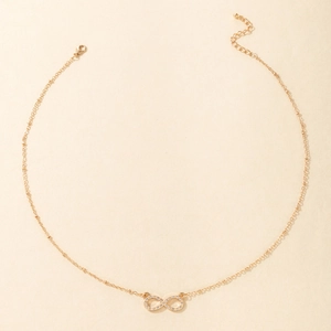Close-up of gold infinity pendant with pavé crystals and adjustable lobster clasp