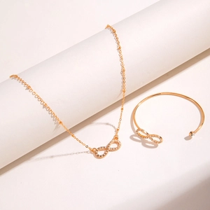 Close-up of golden infinity necklace and cuff bracelet set with sparkling rhinestones