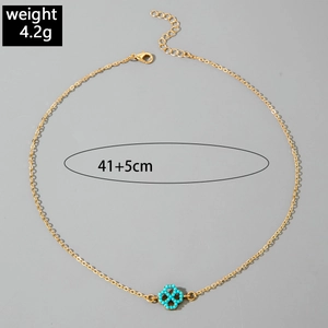 Detail of gold necklace with blue clover pendant, showing adjustable clasp and 4.2g weight