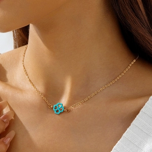 Close-up of golden O-chain necklace with a blue floral turquoise pendant on a model