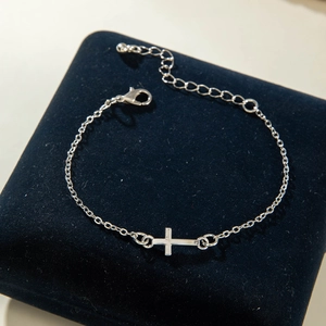 Silver cross necklace detail showing lobster clasp and adjustable extender on velvet