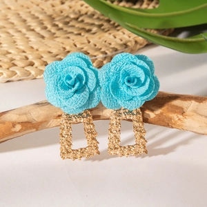Détail de boucles d'oreilles roses en soie bleue avec pendant rectangulaire doré