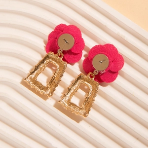 Détail de puce fleur en tissu rose rouge avec pendentif géométrique doré évidé