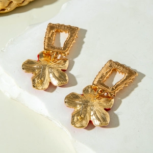 Vue détaillée des boucles d'oreilles fleurs dorées vintage sur une pierre blanche