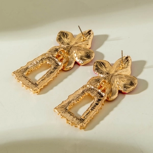 Vue détaillée des boucles d'oreilles fleurs dorées montrant le design des pétales et clous