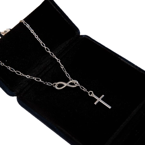 Silver infinity and cross layered necklace presented in a luxury black velvet jewelry box