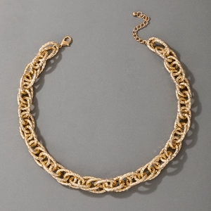 Detailansicht der klobigen goldenen Gliederkette mit strukturierten Ringen und Karabinerverschluss