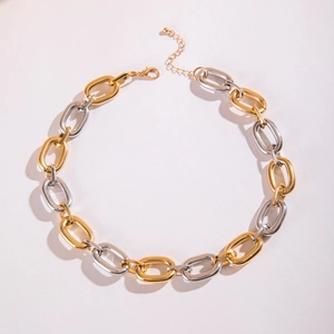 Detail einer klobigen Gold- und Silber-Gliederkette mit Karabiner und Verlängerung