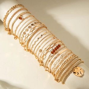 Macro shot of gold-tone multi-layered bracelets with coin pendant on display stand