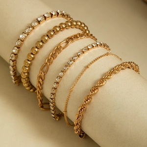 Détails d'un ensemble de 6 bracelets chaîne dorée avec cristaux sur support à bijoux