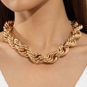 Detailaufnahme einer dicken goldenen Kordelkette, getragen auf weißem Kragen