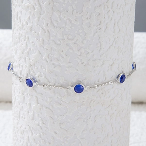 Detalle de un collar plateado con circonitas azules redondas engastadas en bisel fino