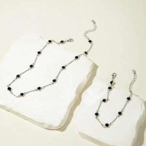 Detalle del conjunto de collar y pulsera de plata con pedrería verde sobre piedras