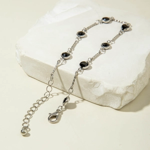 Detalle de la cadena plateada con diamantes de imitación negros redondos y cierre de langosta