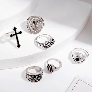 Macro view of vintage silver Gothic rings featuring eagle and cross motifs on white stone