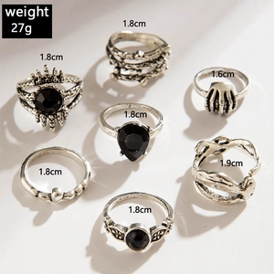 Close-up of 7-piece vintage gothic ring set showing sizes and weights on white background