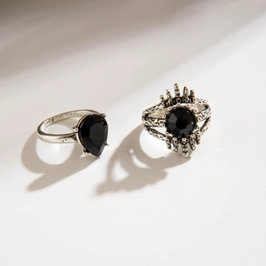 Detail view of retro silver alloy rings with black pear-shaped and round stone settings