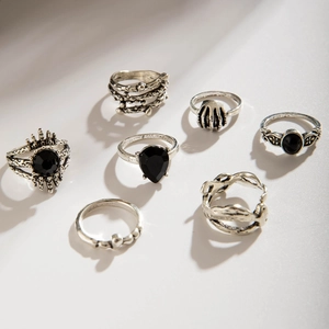 Detail of 7-piece vintage gothic ring set with black stones and skull hand design